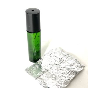 A bottle of lotion next to some foil.