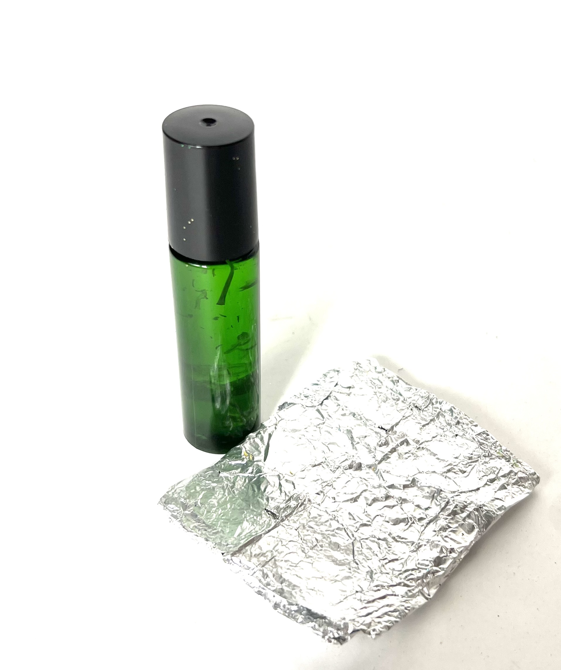 A bottle of lotion next to some foil.