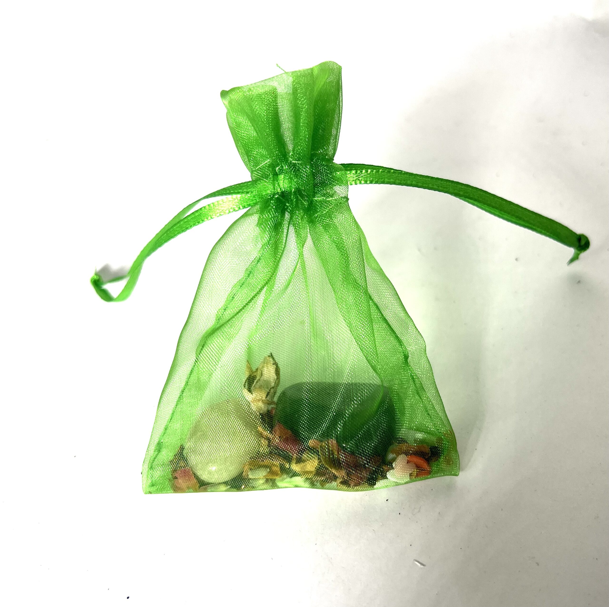 A green bag filled with rocks and shells.