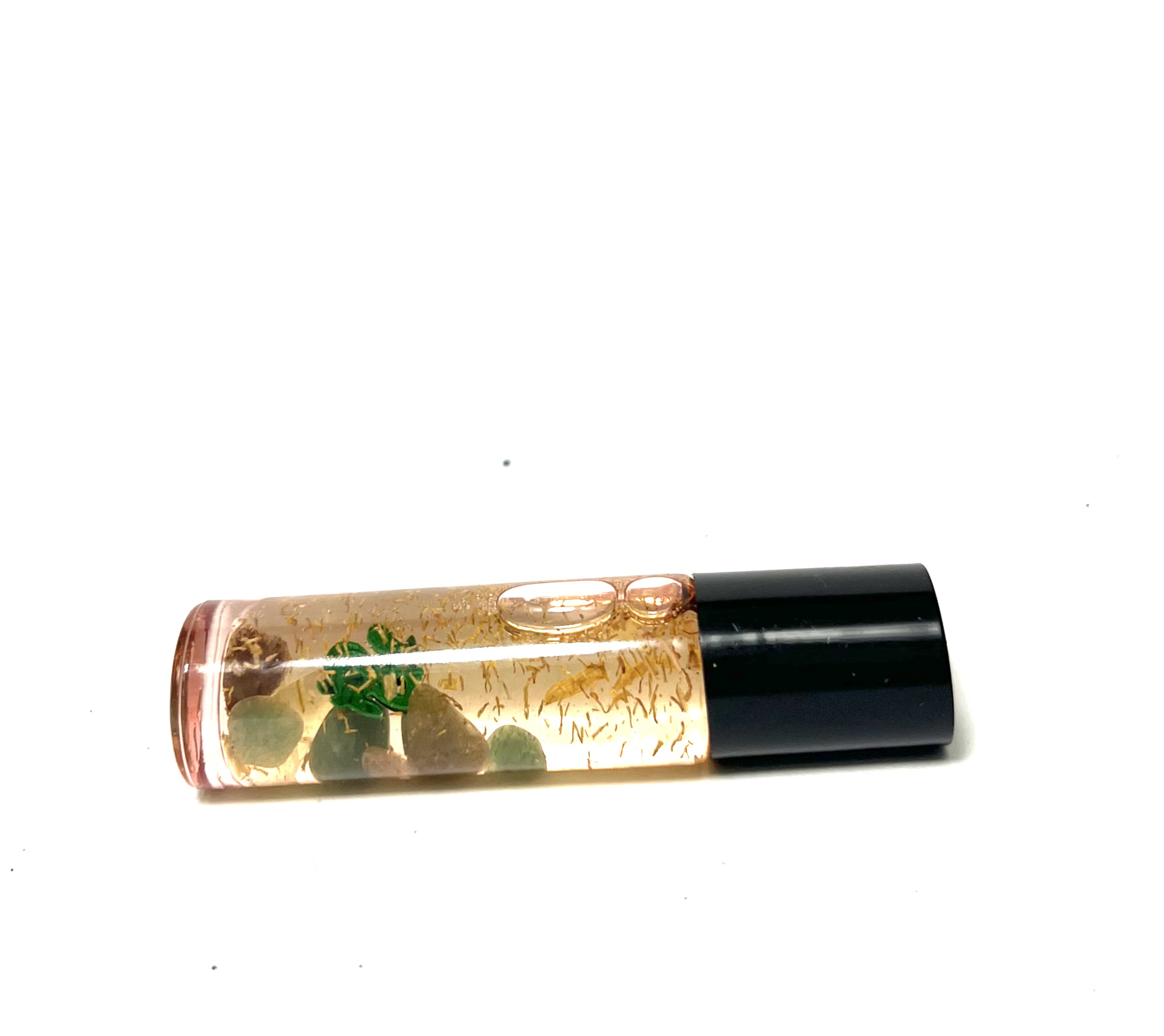 A clear tube of lip gloss with green leaves.