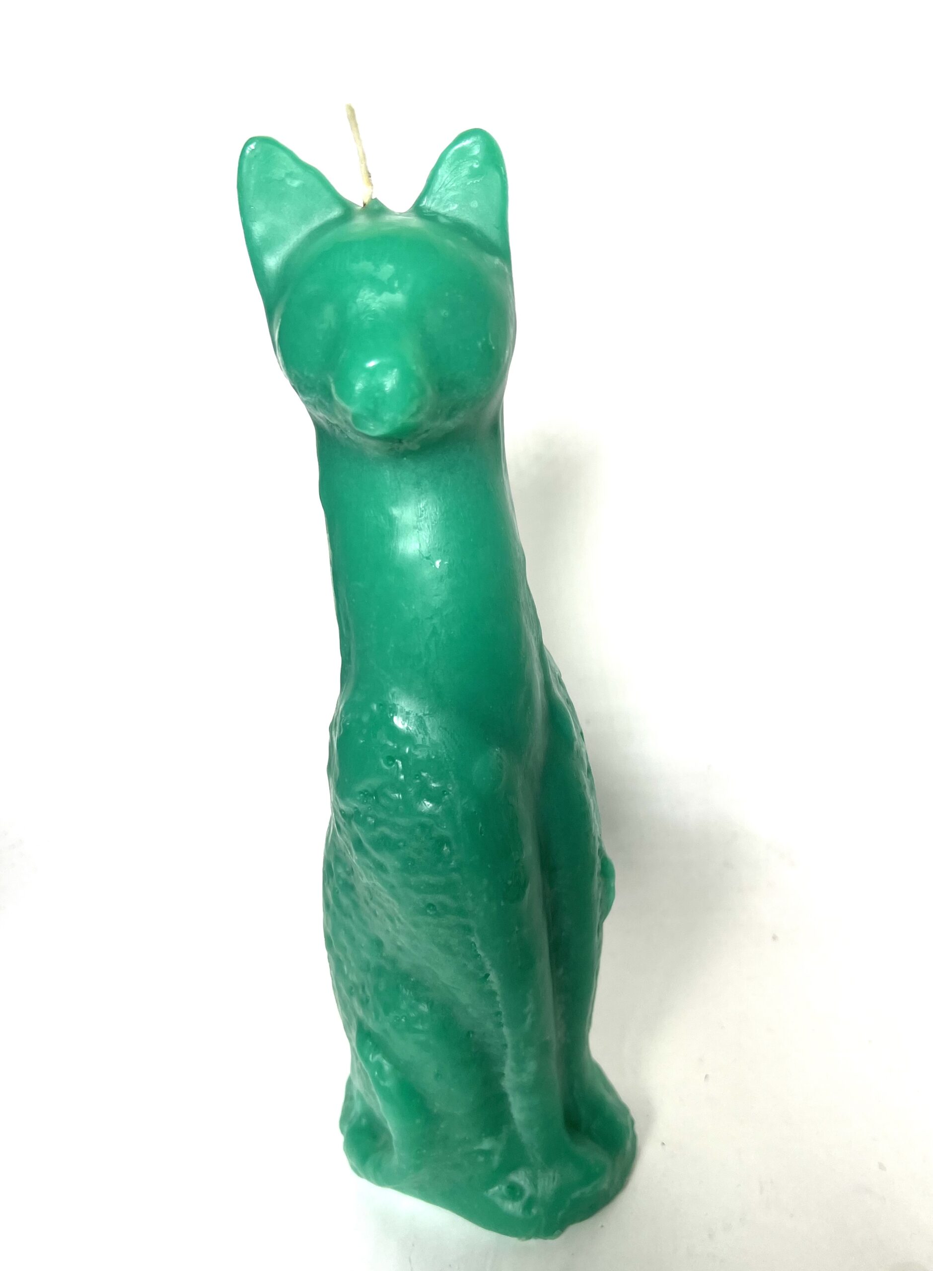 Green cat-shaped candle on white background.