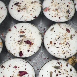 Handmade candles with dried flower decorations on top.