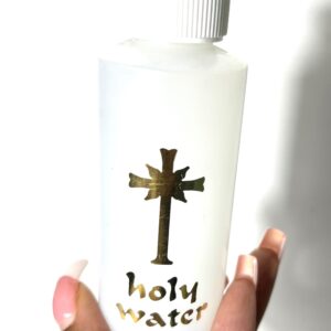 A white bottle labeled 'holy water' with a cross design.