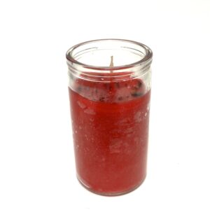 Red scented candle in a clear glass jar.