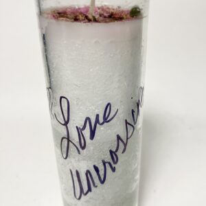 Tall candle with 'Love Universe' written in purple handwriting.
