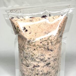 Transparent bag filled with a granular mixture of light and dark particles.